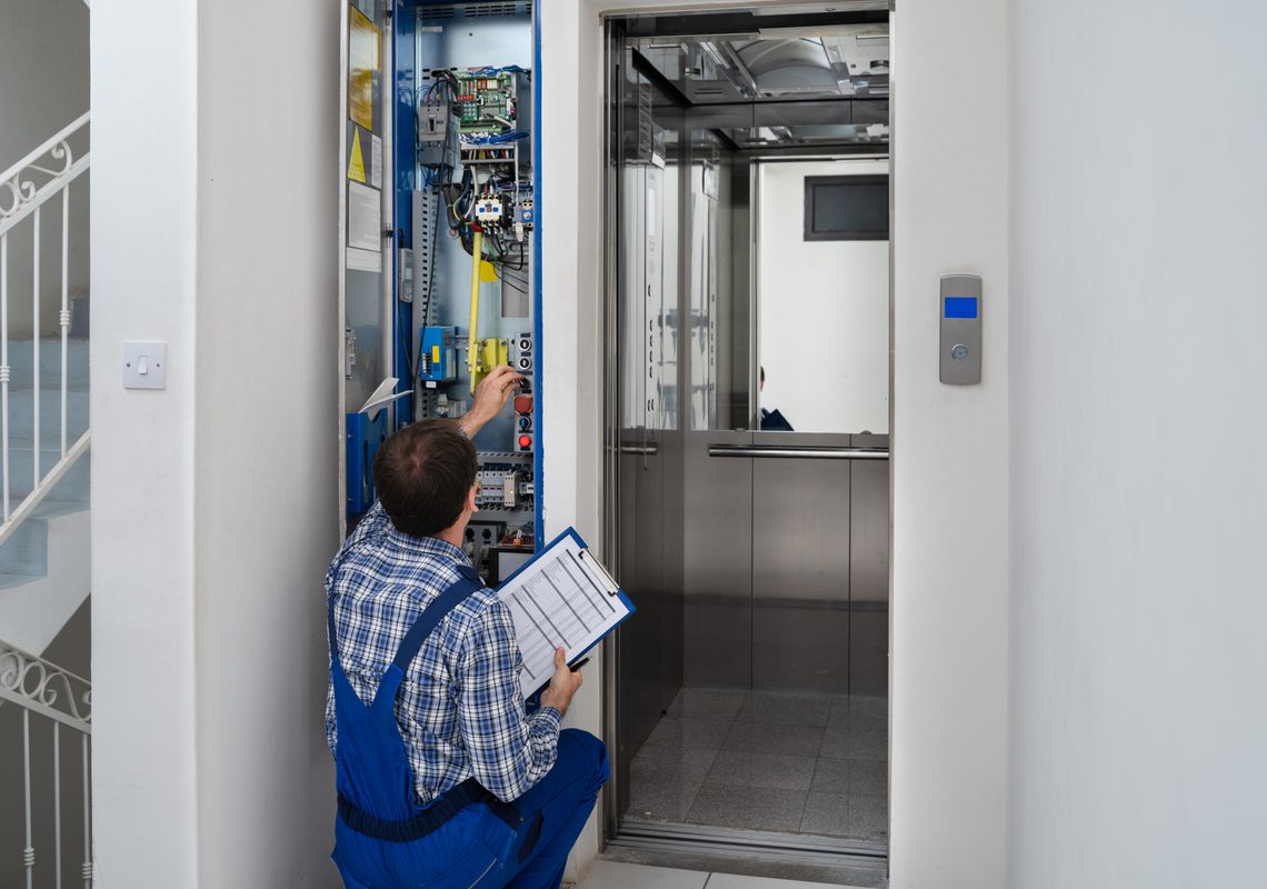 Technician inspecting an elevator in a community building